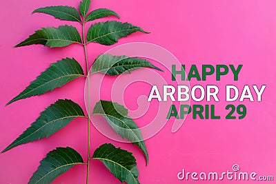 Happy Arbor Day April 29 with green leaves on a pink Stock Photo