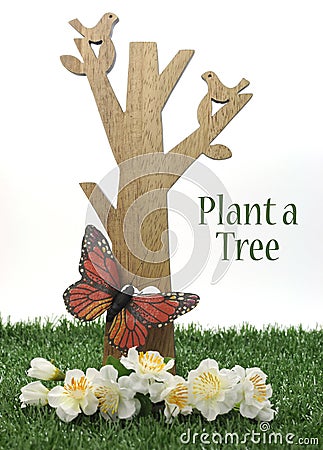 Happy Arbor Day, Plant a Tree greeting for last Friday in April, with wood tree, carved birds, butterfly and green grass Stock Photo