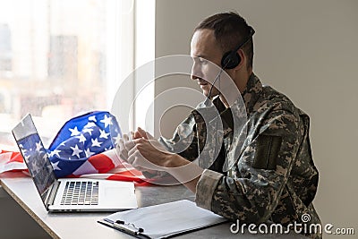 Happy army soldier having video call over laptop Stock Photo