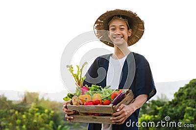 Happy Asia farmer smiling while hold various of vegetable product Stock Photo