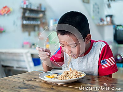 Happy Asian boy eating delicious noodle Stock Photo