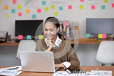 Happy Asian business woman in casual working with laptop and smile Stock Photo