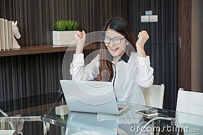 Happy Asian business woman finishing works in office Stock Photo
