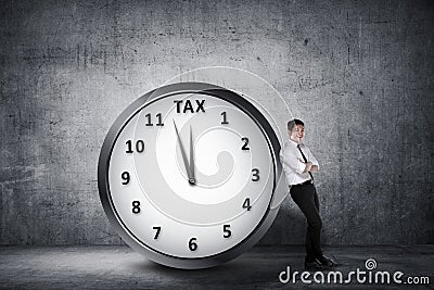 Happy asian businessman lean back on the clock with deadline tim Stock Photo