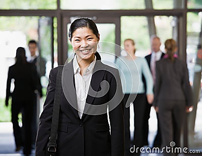 Happy Asian businesswoman holding briefcase Stock Photo