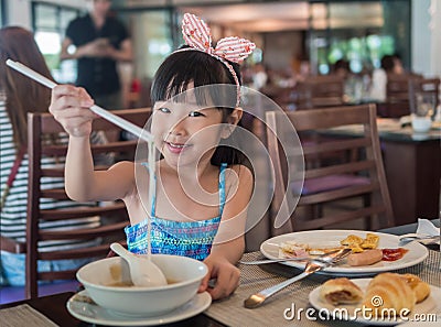 Happy Asian child eating delicious noodle with chopstick Stock Photo