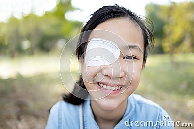 Happy asian child girl cover with blindfolded bandaged eye after surgery or treatment of strabismus,lazy eye, hygienic,prevent Stock Photo