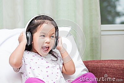 Happy asian child girl having fun to listen the music Stock Photo