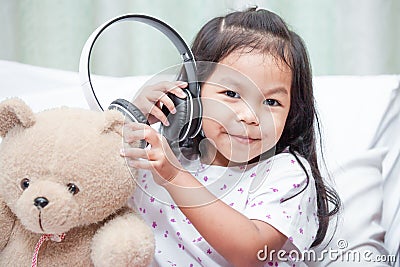 Happy asian child girl playing with her teddy bear Stock Photo