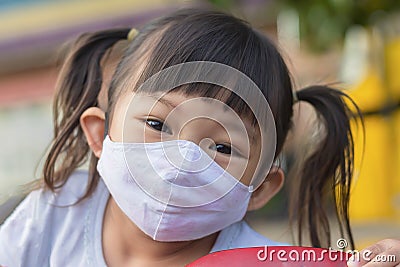 Happy Asian child girl smiling and wearing fabric mask Stock Photo