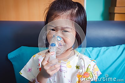 Happy asian child holds a mask vapor inhaler for treatment of asthma. Stock Photo