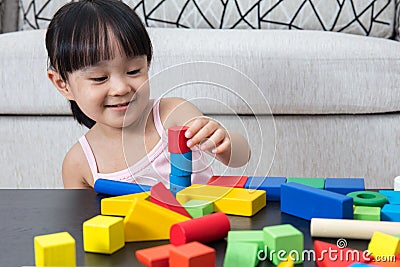 Happy Asian Chinese little girl playing building blocks at home Stock Photo