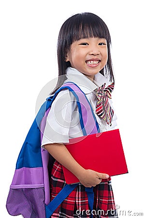 Happy Asian Chinese little girl with school bag and book Stock Photo