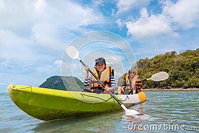 Happy asian couple kayaking together on the beatiful sea or canoe at tropical bay Stock Photo