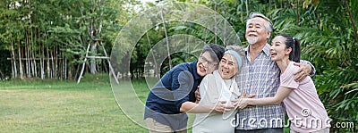 happy asian family hugging together with adult son young daughter senior father and old mother in garden park back yard at home. Stock Photo