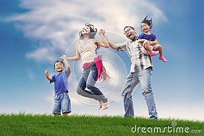 Happy Asian Family in Meadow Stock Photo