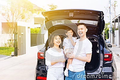 Happy Asian family standing on the back of SUV car with smile and happiness. Stock Photo