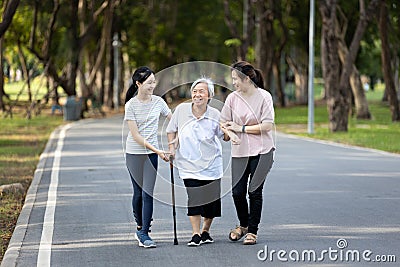 Happy asian family strolling embracing while relaxing and enjoying summer day in city park at leisure,smiling senior grandmother, Stock Photo