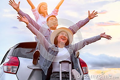 Happy Asian friends spread arms widely and breathed fresh air with happiness mood in on raod trip in car trunk. People lifestyle Stock Photo