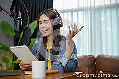 Happy asian girl record a podcast with headphones and microphone Stock Photo