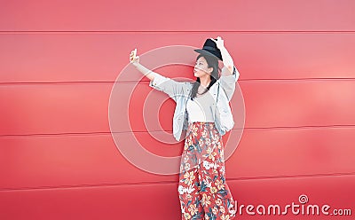 Happy Asian girl taking selfie with mobile phone outdoor - Social influencer woman having fun with new trends smartphone apps Stock Photo