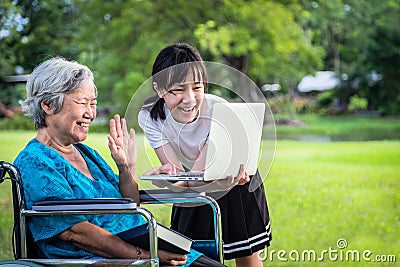 Happy asian granddaughter enjoy smiling and senior grandmother using video conferencing with laptop computer,child girl having Stock Photo