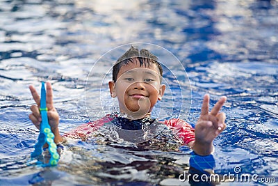 Happy asian kid boy swiming on swiming pool in the summer Stock Photo