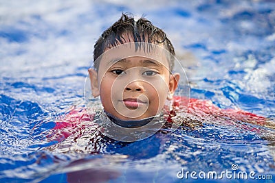 Happy asian kid boy swiming on swiming pool in the summer Stock Photo