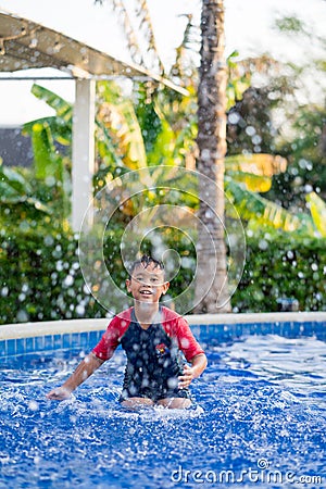 Happy asian kid boy swiming on swiming pool in the summer Stock Photo