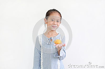 Happy asian little kid girl hold and eating Custard Cake over white background Stock Photo