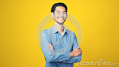 Happy asian man crossed arms while standing over isolated yellow background, Portrait of asia male smiling and looking at camera Stock Photo