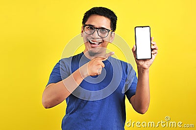 Happy Asian man showing a phone screen and pointing Stock Photo
