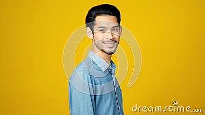 Happy asian man crossed arms while standing over isolated yellow background, Portrait of asia male smiling and looking at camera Stock Photo