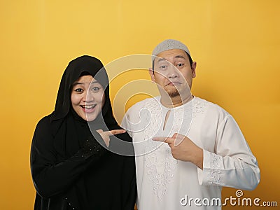 Happy Asian muslim couple proud of each other, pointing and smiling, lovefamily good relationship Stock Photo