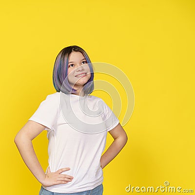 Happy Asian Teenager Girl, Dressed In White Shirt, Isolated Portrait On Yellow Background. Teenage Life, With Girl's Stock Photo