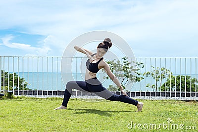 Happy Asian woman wearing black sport wear relaxing in yoga High Lunge twist pose Stock Photo