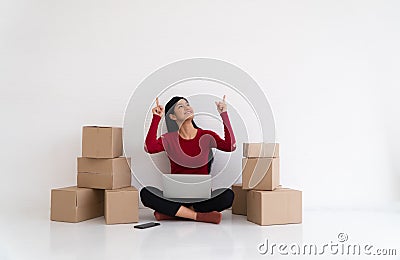 Happy Asian young entrepreneur, Smile for sales success and pointing finger up at the home office and store, Concept of merchant Stock Photo