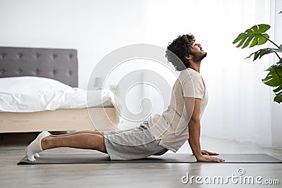 Happy athletic indian man stretching his body at home Stock Photo