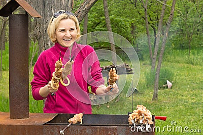 Happy attractive blond woman cooking on a BBQ Stock Photo