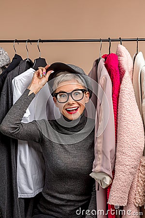 Happy attractive stylish girl among clothes in wardrobe Stock Photo