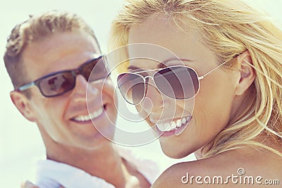 Happy Attractive Woman and Man Couple In Sunglasses At Beach Stock Photo