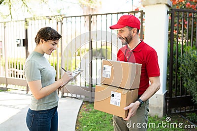 Young woman signing documents from a delivery courier Stock Photo