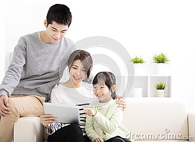 Happy Attractive Young Family watching the tablet Stock Photo