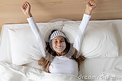 Happy awakened woman took off mask stretching after night sleeping Stock Photo