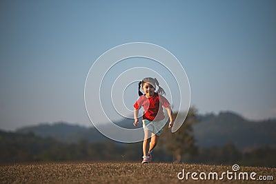 Happy baby asian girl smiling. little girl running and smiling at sunset happy baby girl smiling. little baby running at sunset. Stock Photo