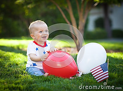 Happy baby boy playing with rend and white balloons Stock Photo
