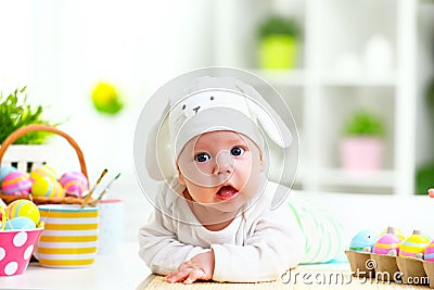 Happy baby child with Easter bunny ears and eggs and flowers Stock Photo