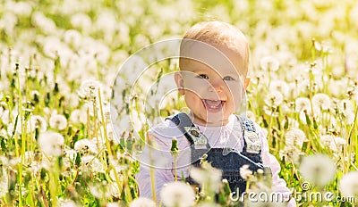 Happy baby girl on meadow with white flowers Stock Photo