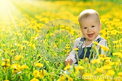 Happy baby girl on meadow with yellow flowers on the nature Stock Photo