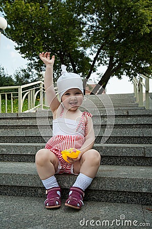 Happy baby girl sitting on steps Stock Photo